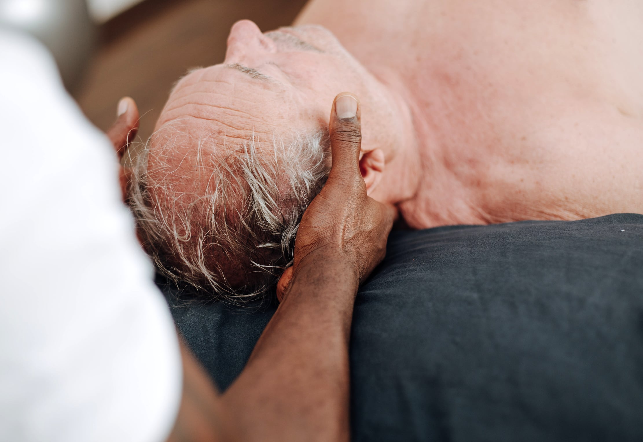 Physiotherapeut mit Patient bei einer Sonderform (Craniomandibuläre Dysfunktion) der mauellen Therapie